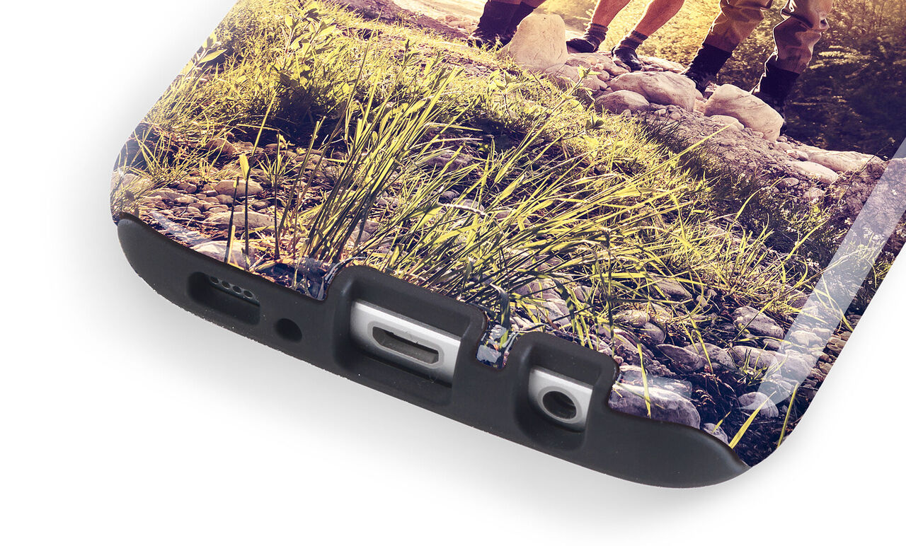 Close-up of a personalized phone case with photo and green grass in the background.