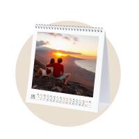 Couple sitting on a mountain enjoying the sunset, featured in a CEWE photo calendar.