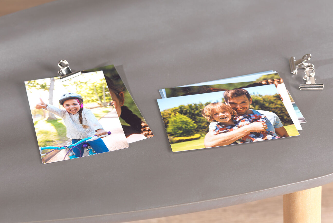 Colorful photos are displayed on a table, including one of a child on a bicycle and another of an adult with a child.