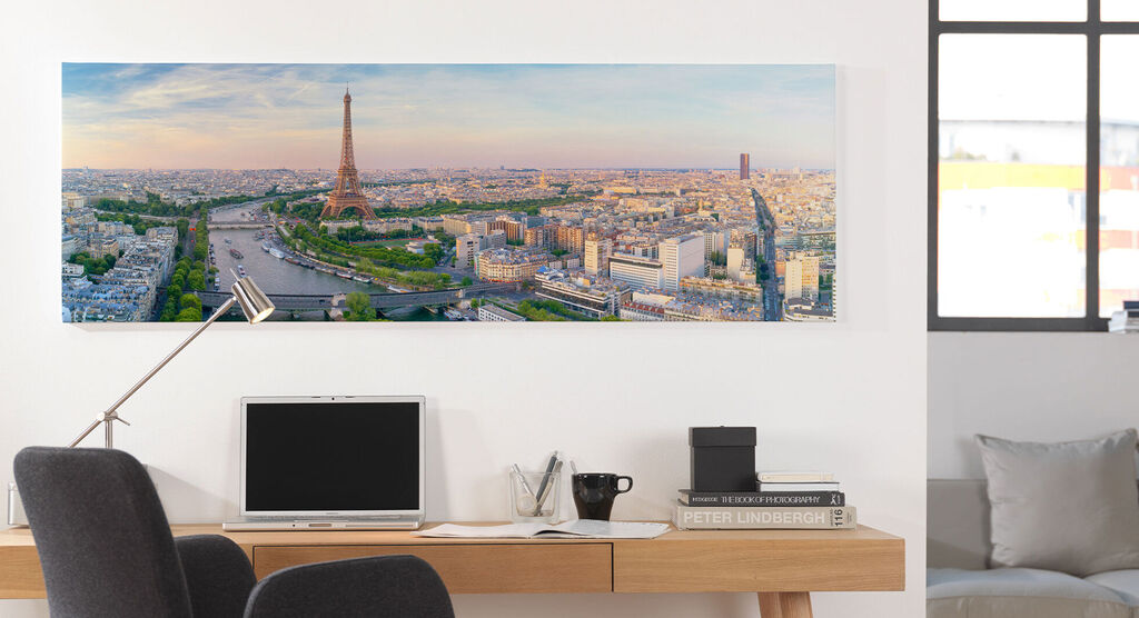 A beautiful view of Paris with the Eiffel Tower and the Seine at sunset in a modern workspace.