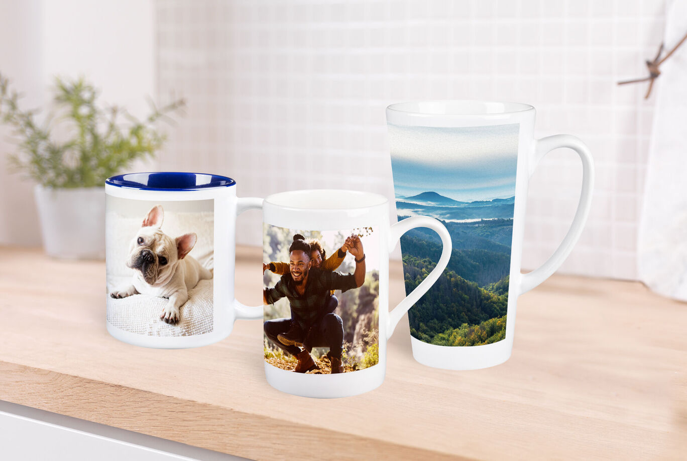 Three colorful mugs with personal photos: dog, friend celebrating, and landscape.