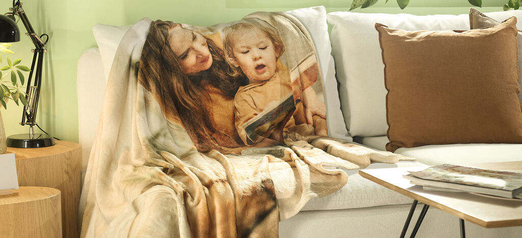 Cozy couch with a unique, personalized photo blanket and lovely decorations in soft colors.