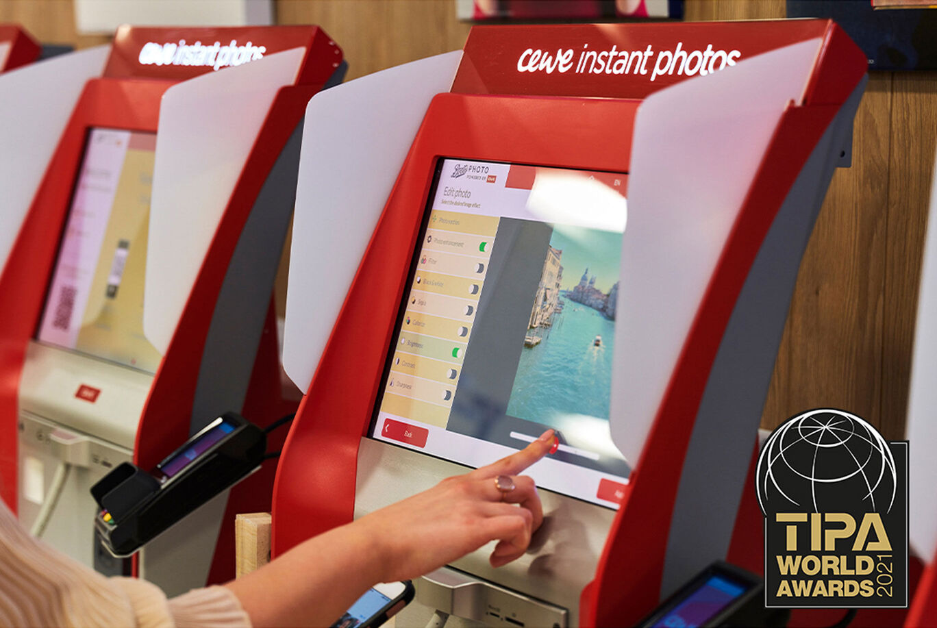 A person selects an image on a CEWE photo service screen.