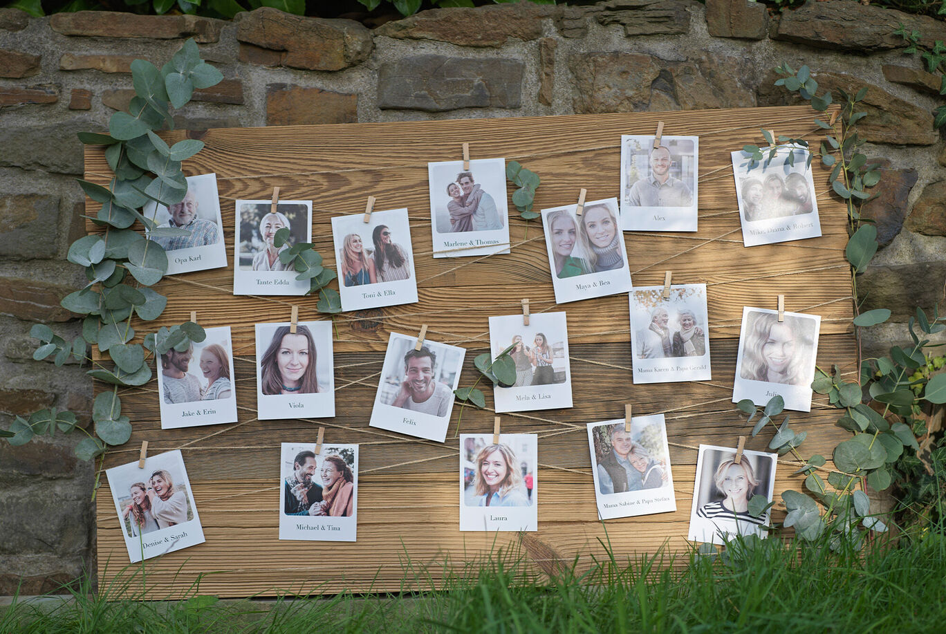 A collage of white photo cards with happy people hanging on a wooden board