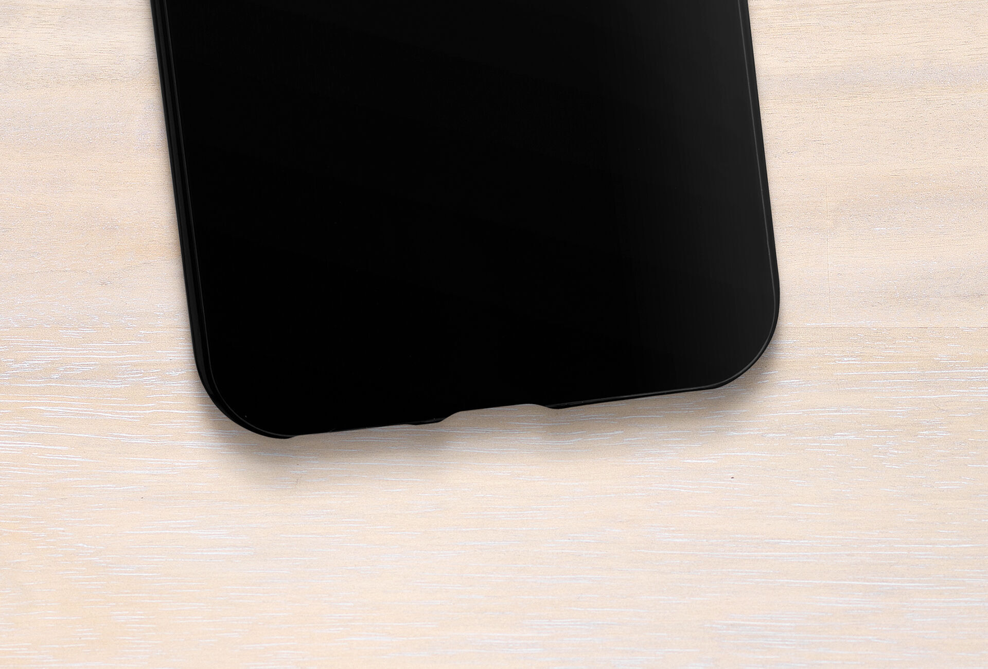 Black smartphone on a light wooden table.