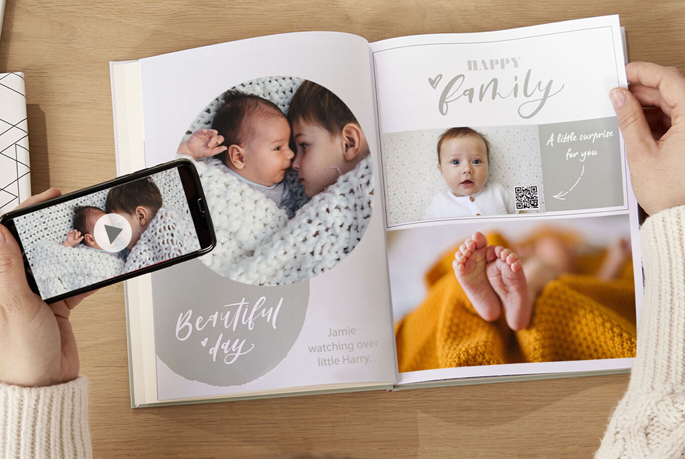 An open photo book with personal layout shows loving moments. Pages with images of a baby and a heartfelt message are visible.