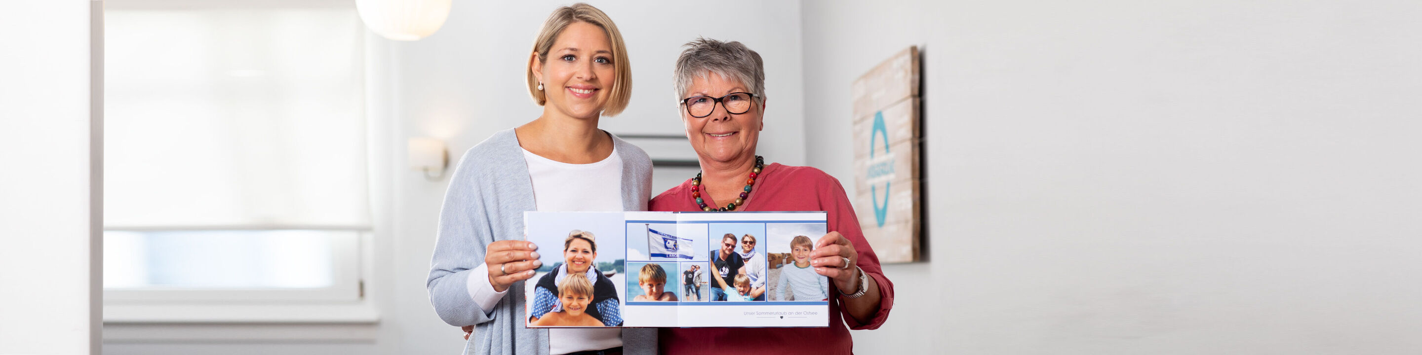 Two people joyfully holding a photo book. It shows happy moments and memories.