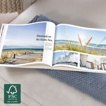 CEWE photo book with images from Denmark at the Baltic Sea, opened on a table.