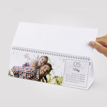 A cheerful calendar with an image of people smiling and enjoying time outdoors
