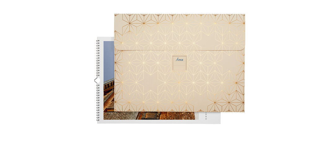 CEWE photo calendar with elegant design and golden accents, open and ready to flip through
