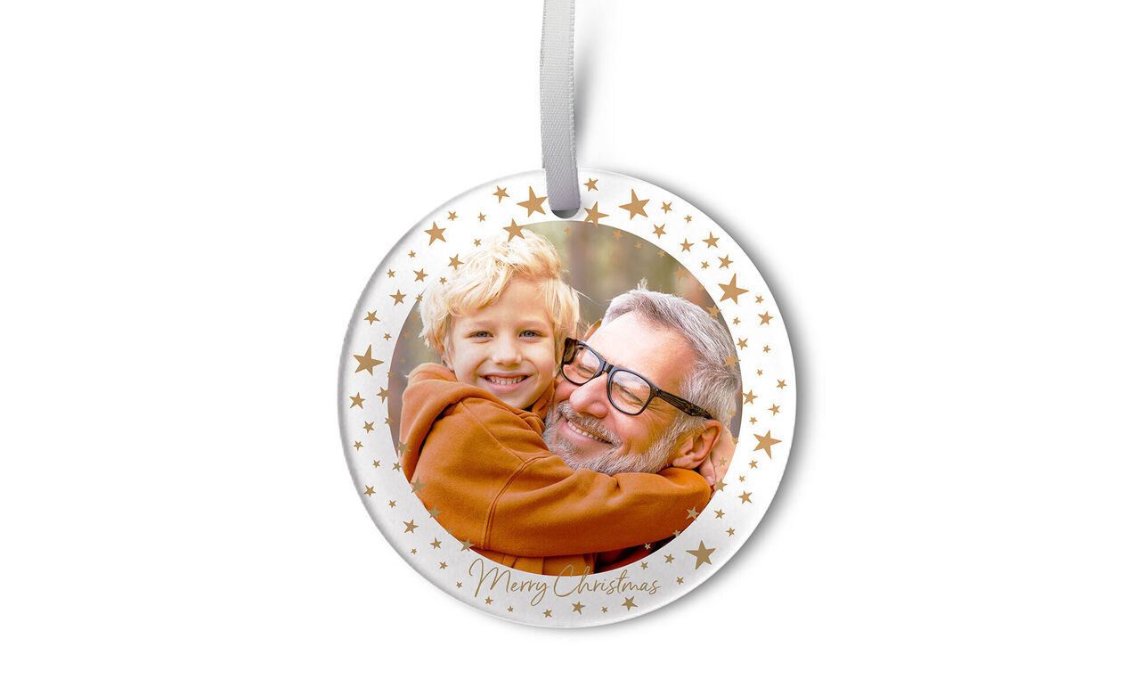 A Christmas ornament with golden stars capturing a heartfelt moment between two people.