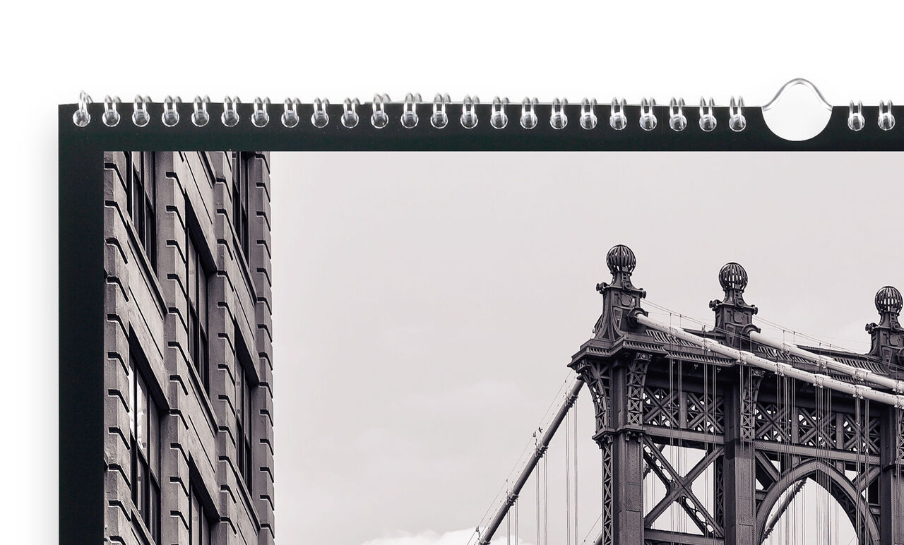 A high-quality CEWE photo calendar displays a black-and-white photo of the Brooklyn Bridge with a building in the foreground.