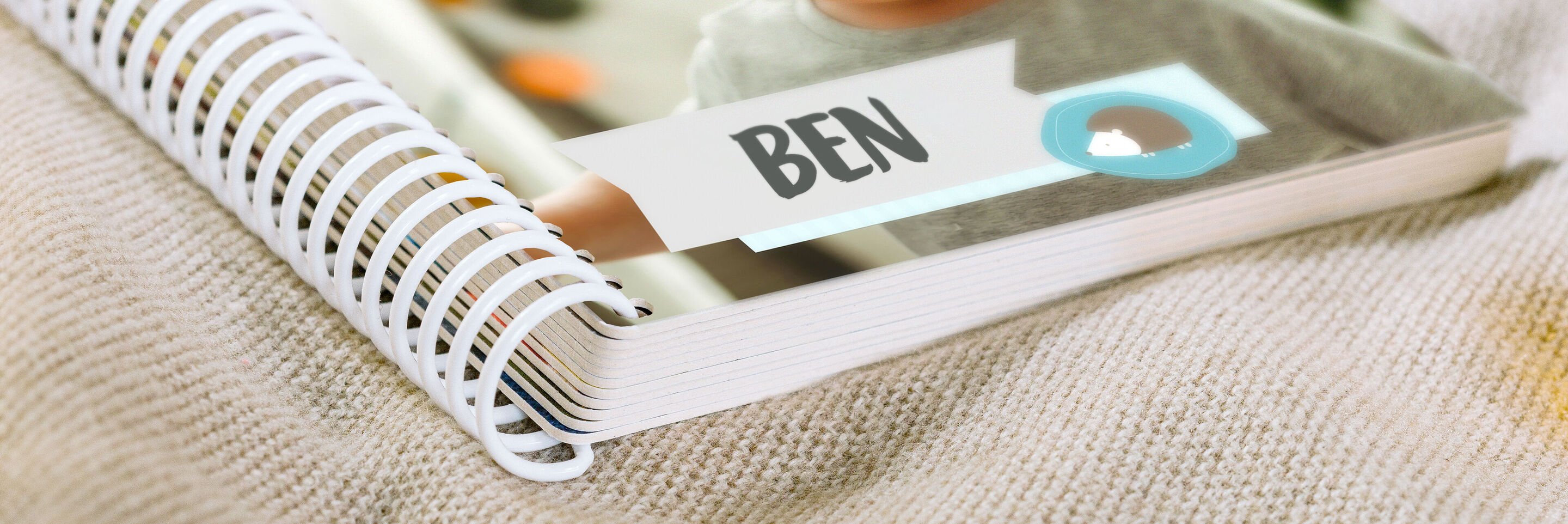 An open CEWE photo book with a picture of Ben and colorful lettering.