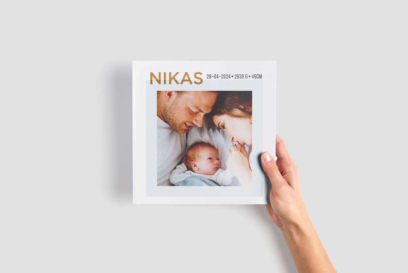 A lovingly designed photo book named "NIKAS" with two photos on the cover. It shows joy for the new chapter.