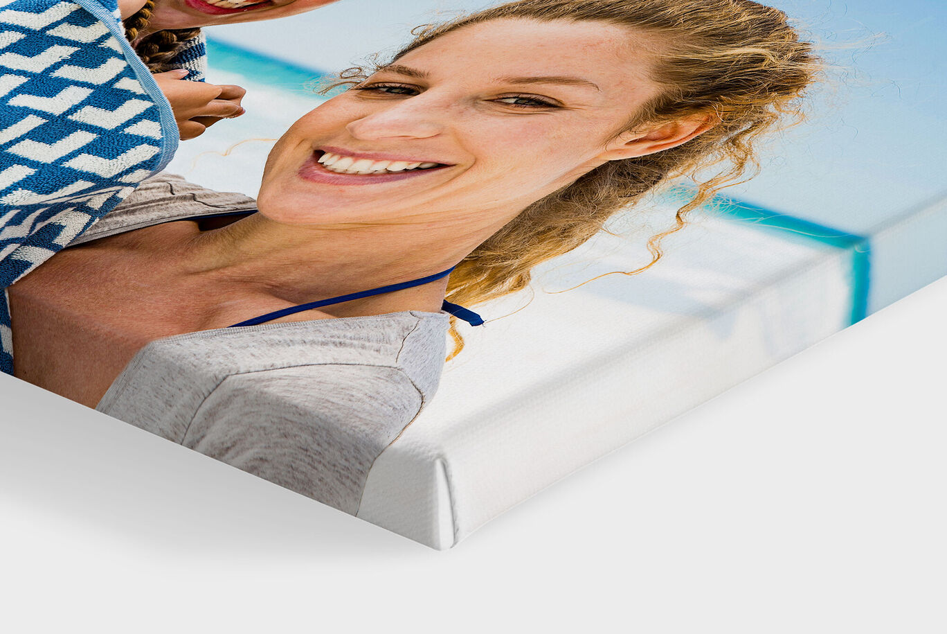 A close-up of a smiling woman holding a friend in the photo. They enjoy a happy moment at the beach.