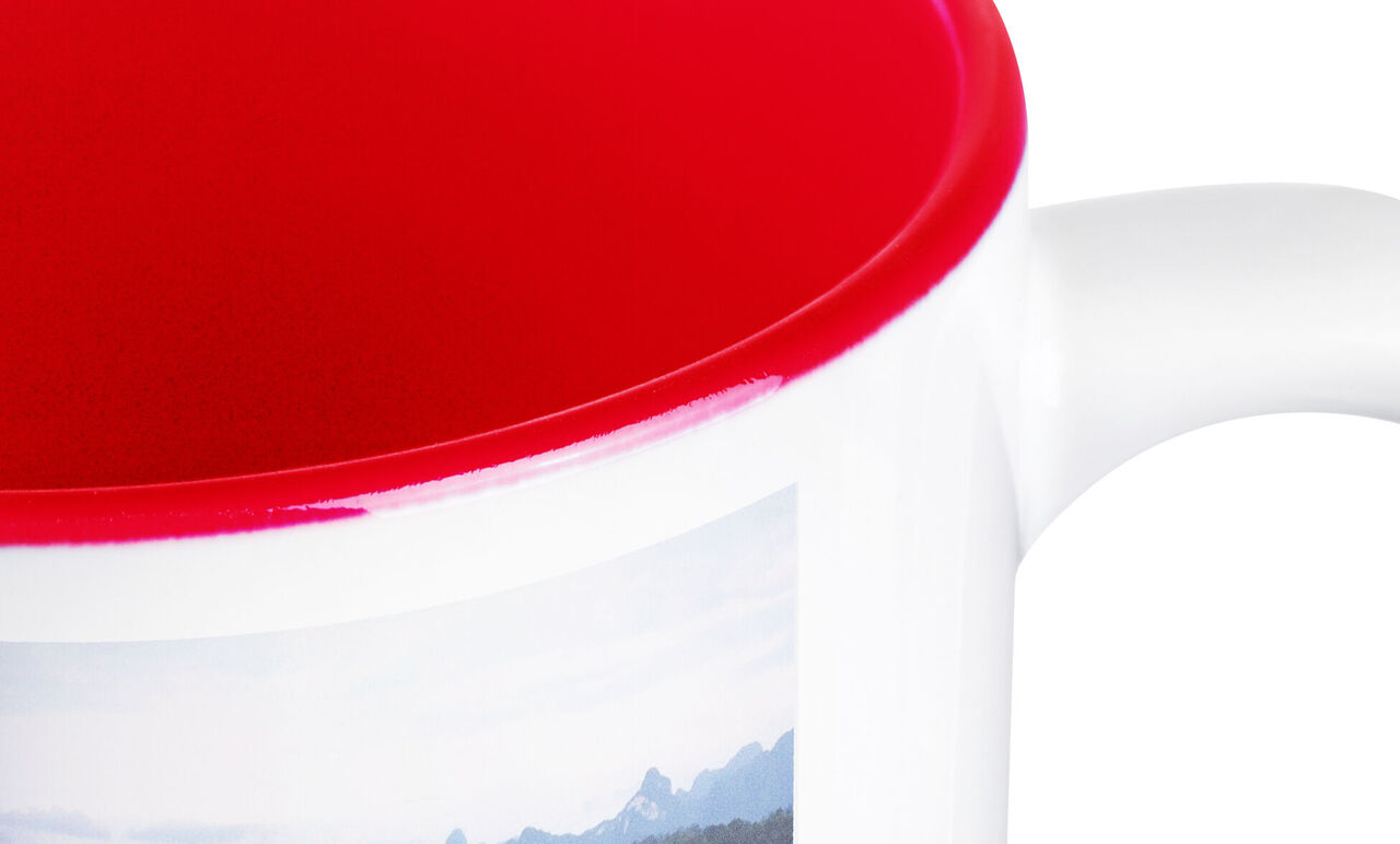Red interior of a mug with mountain motif on the outside