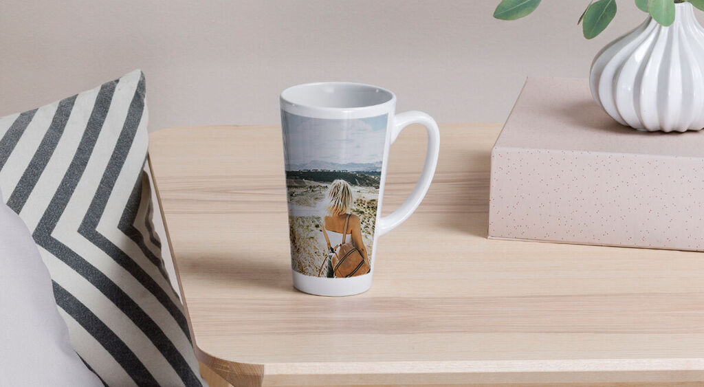 A person looks at a landscape while holding a cup in their hand.