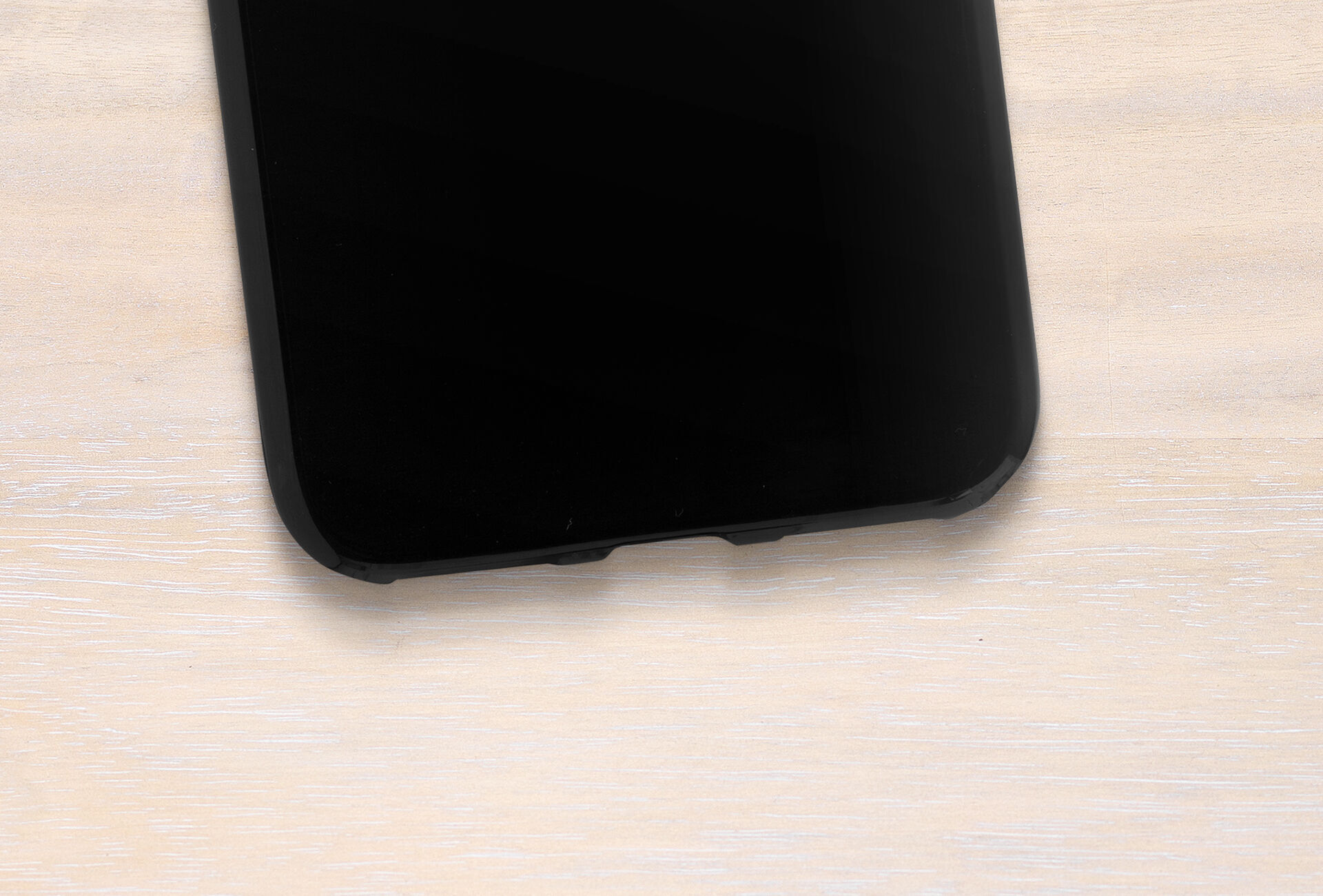 Black smartphone on a light wooden background.