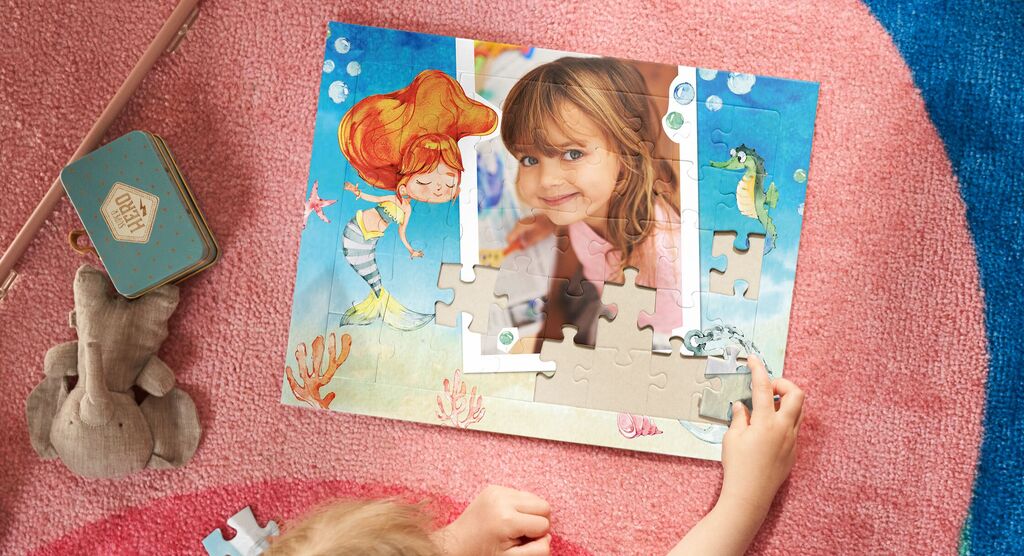 A child puzzles with a lovingly designed underwater motif surrounded by colorful details.