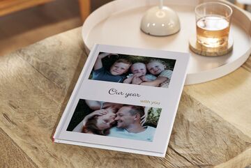 A beautifully designed photo book titled 'Our year with you'. It shows memorable moments of a family.