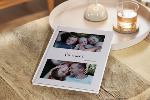 A beautifully designed photo book titled 'Our year with you'. It shows memorable moments of a family.