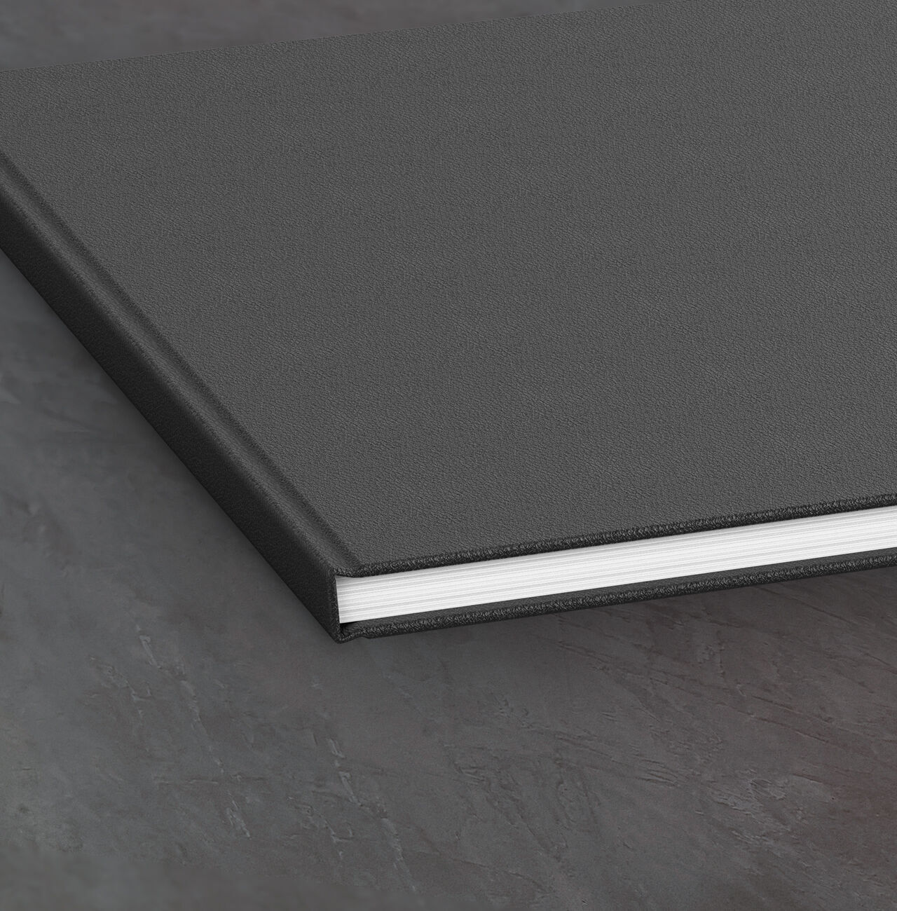 Black photo book with white page edges on a plain surface.
