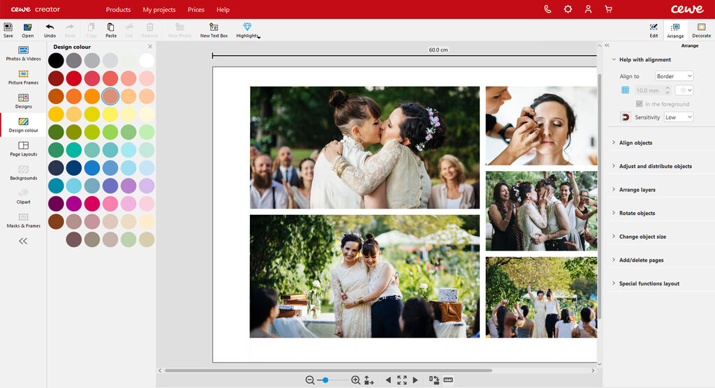 Two brides embrace warmly outdoors, surrounded by happy guests and colorful flowers.