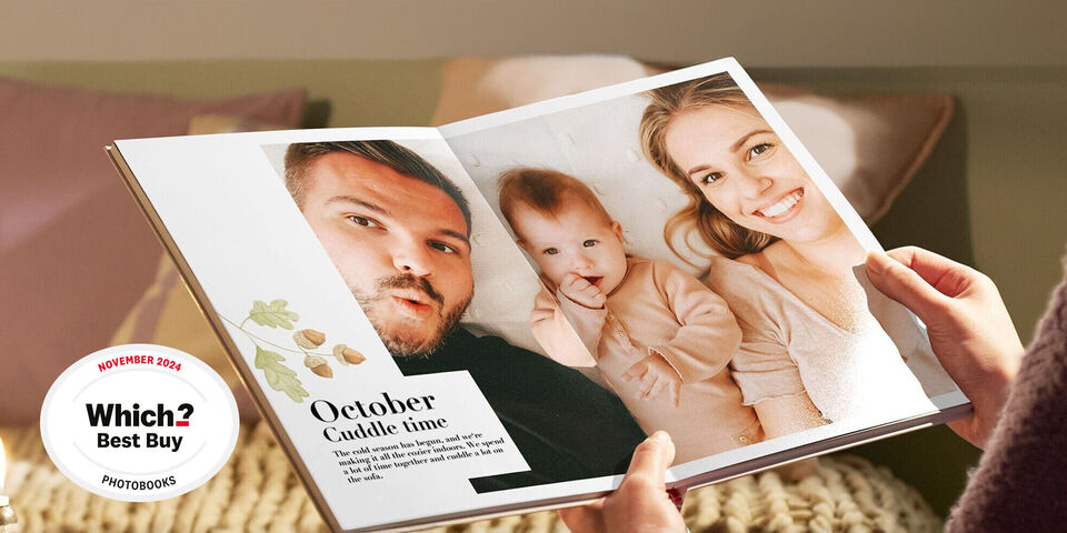 A person holds an open photo book with pictures of children and personal memories. Focus on sharing and appreciating moments.