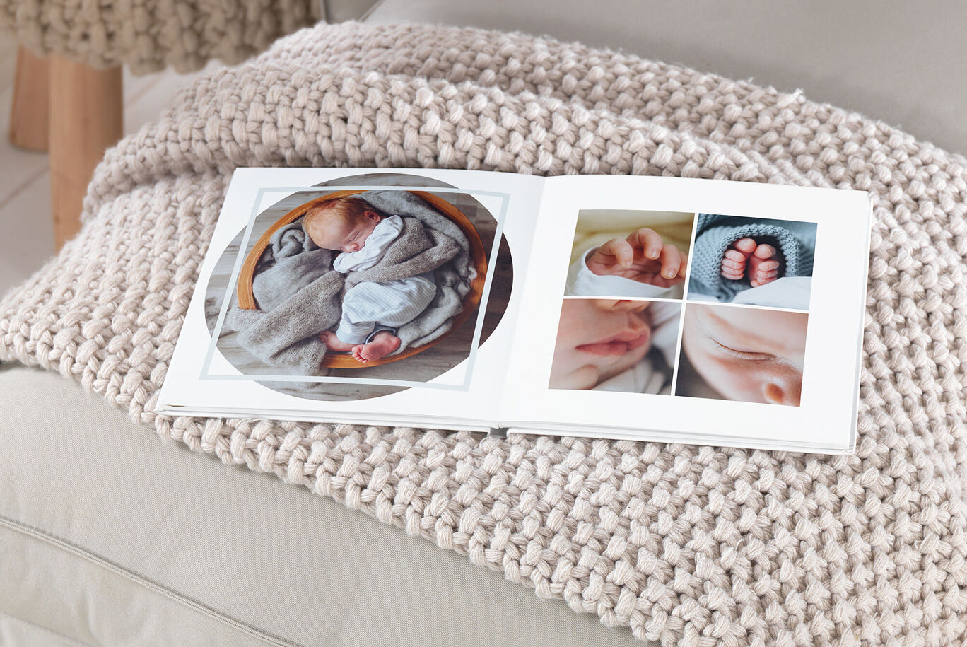 A CEWE photo book with pictures of a sleeping baby in a blanket. It lies on a bright, knitted fabric.