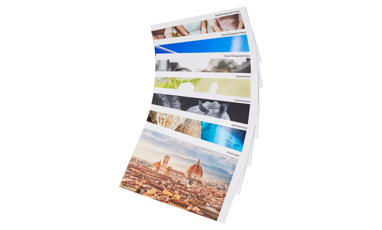The image shows several pages of a CEWE photo book in fan format, featuring various landscape photos and experiences.