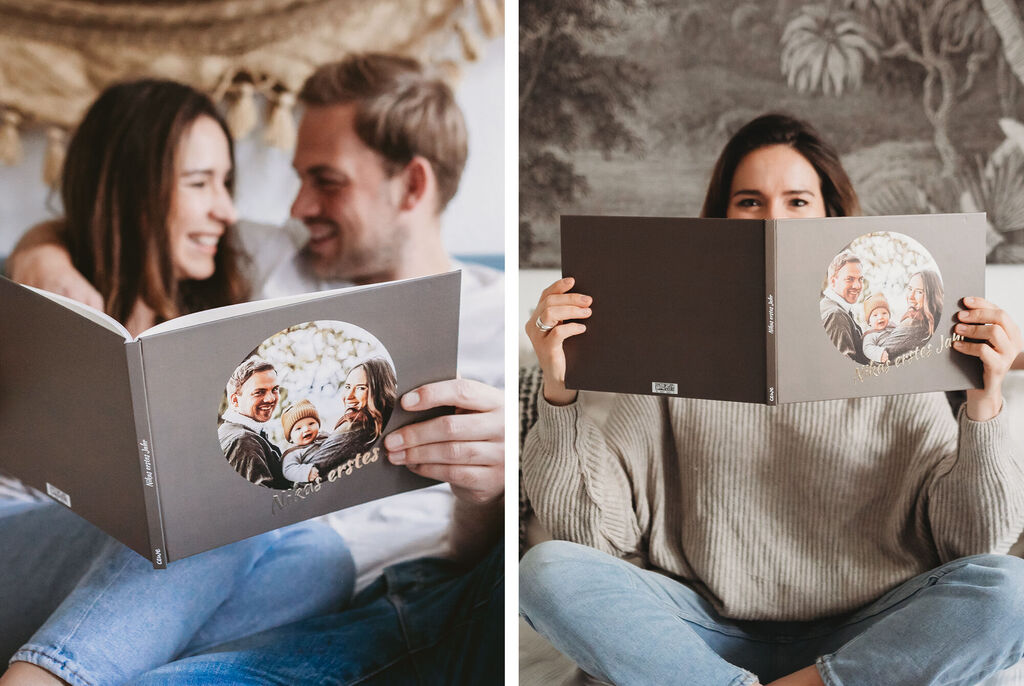 A couple looks at a photo book on a cozy couch.