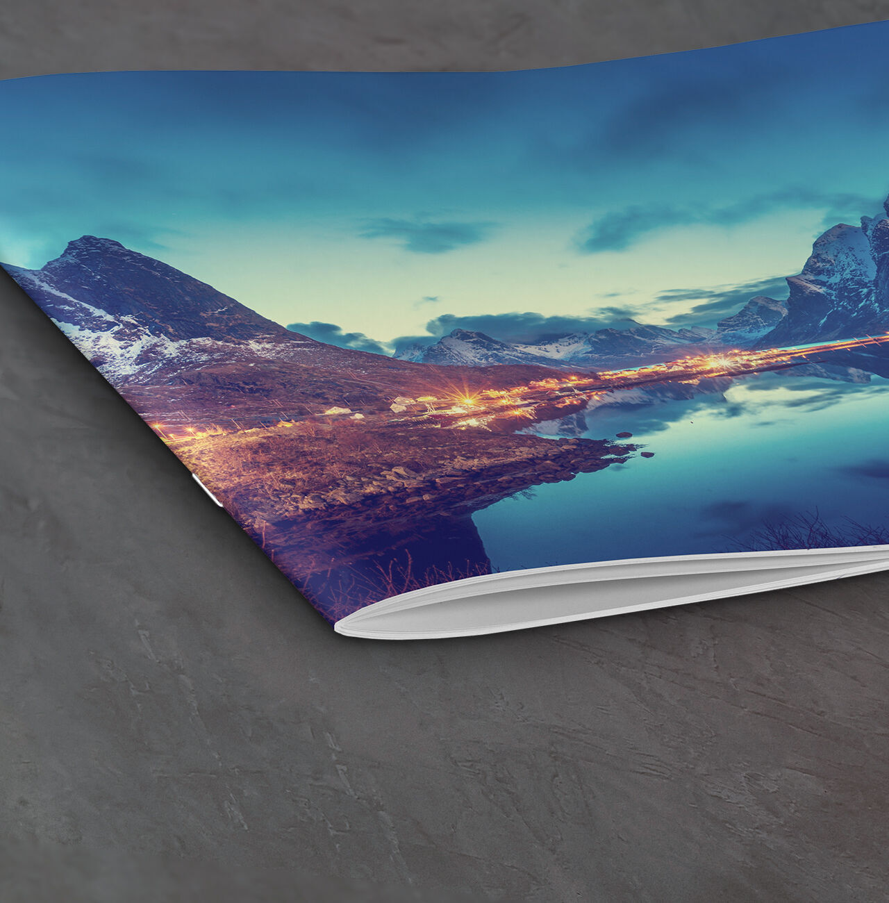 A beautiful photo book showing a stunning landscape with mountains and a calm lake.