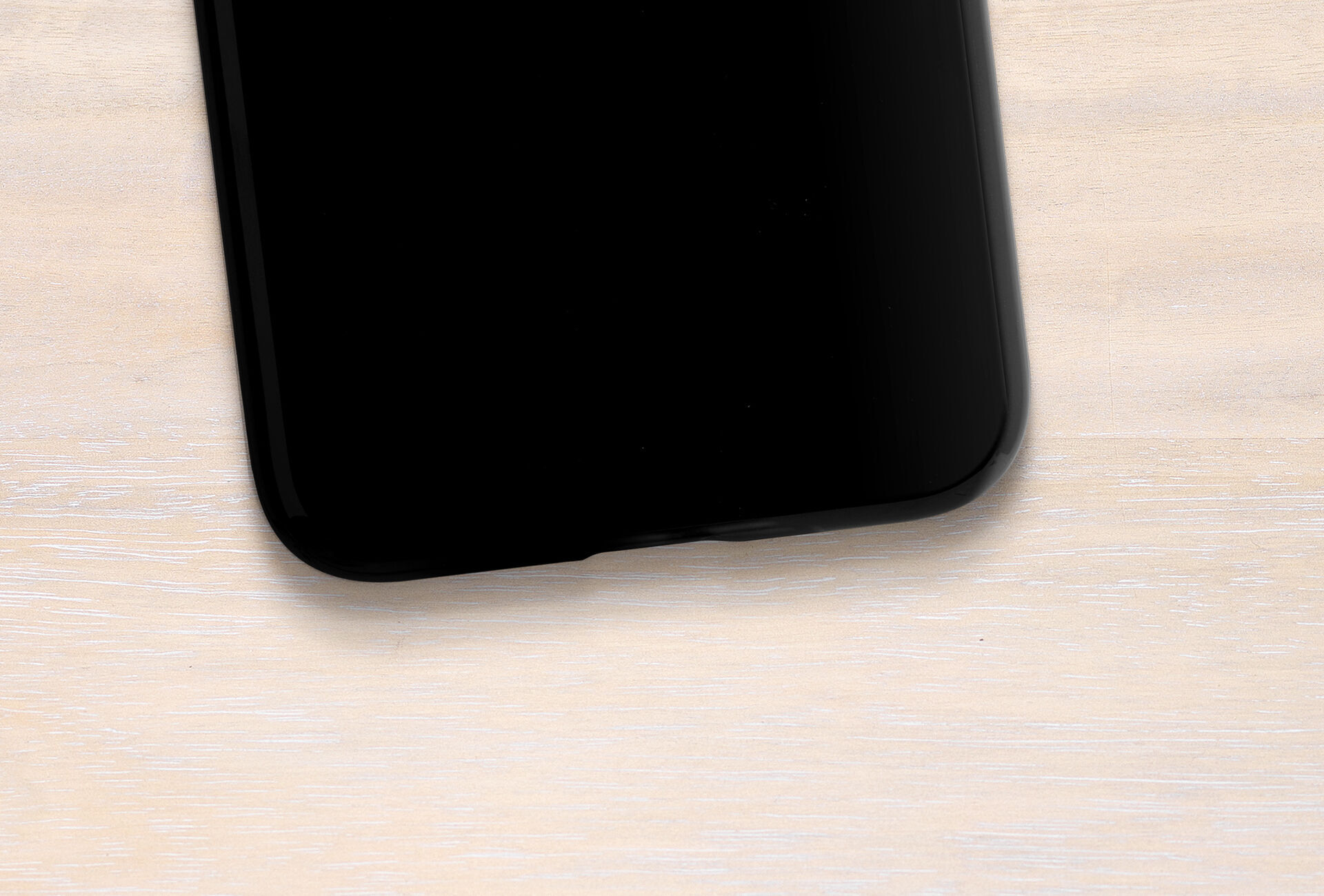 Black smartphone on a light wooden table