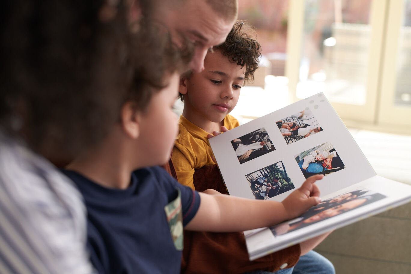 A family enjoys a photo book filled with colorful memories.