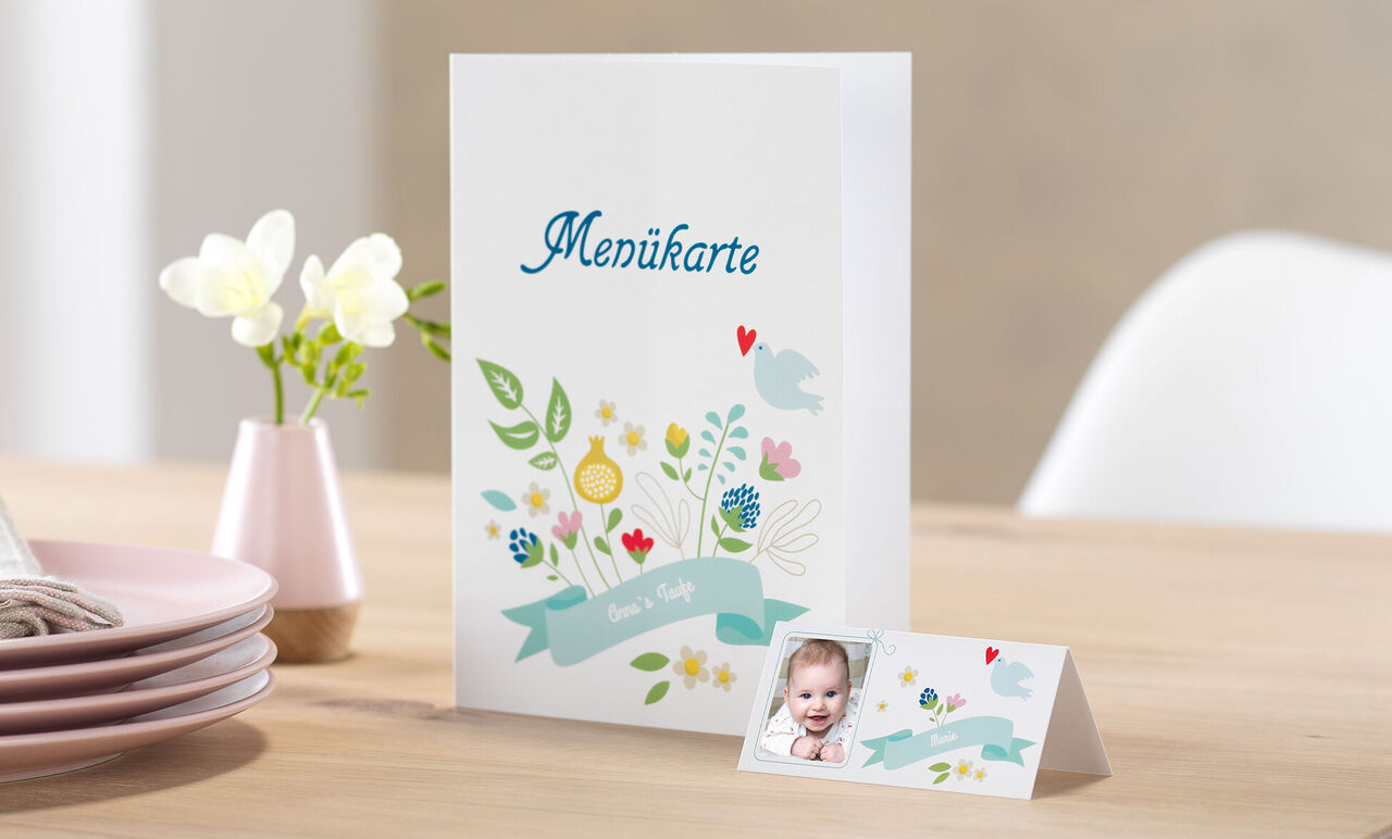 Elegant menu card with colorful flowers and birds, personalized place card beside it.