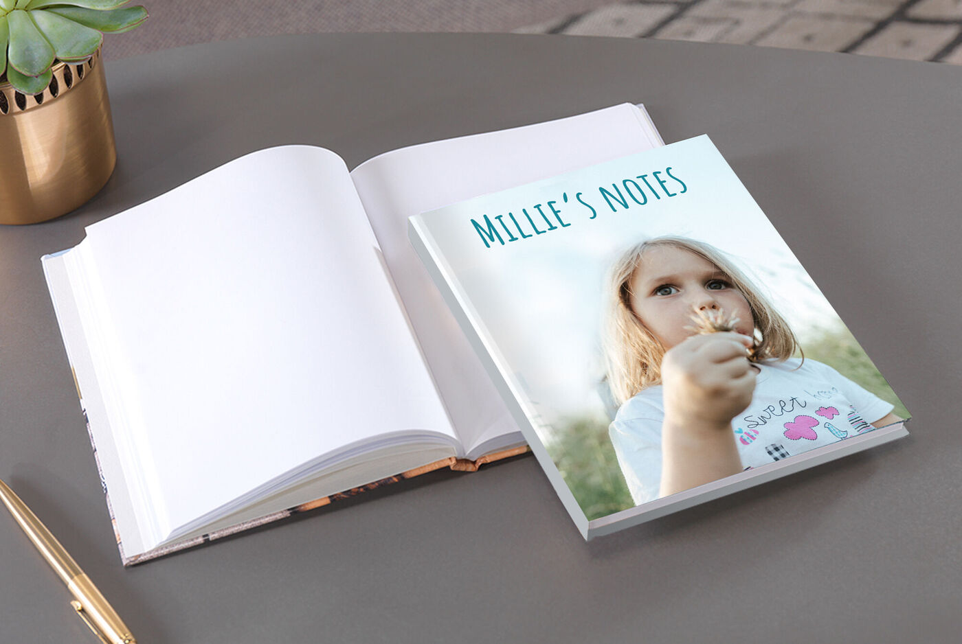 Open notebook next to a CEWE photo book titled Millie’s Notes.