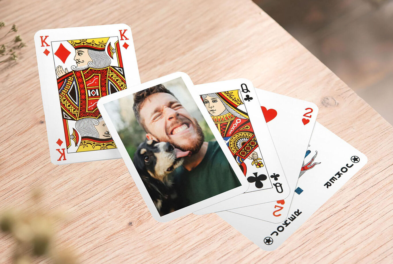 A card game on a wooden table featuring images of a dog and two playing cards.