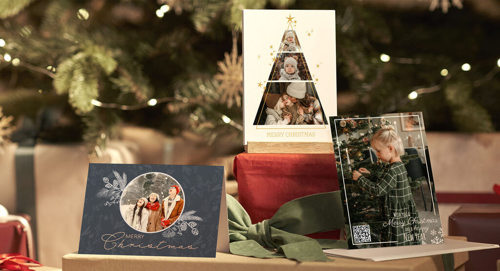 Three festive greeting cards lovingly placed on gifts under a Christmas tree.