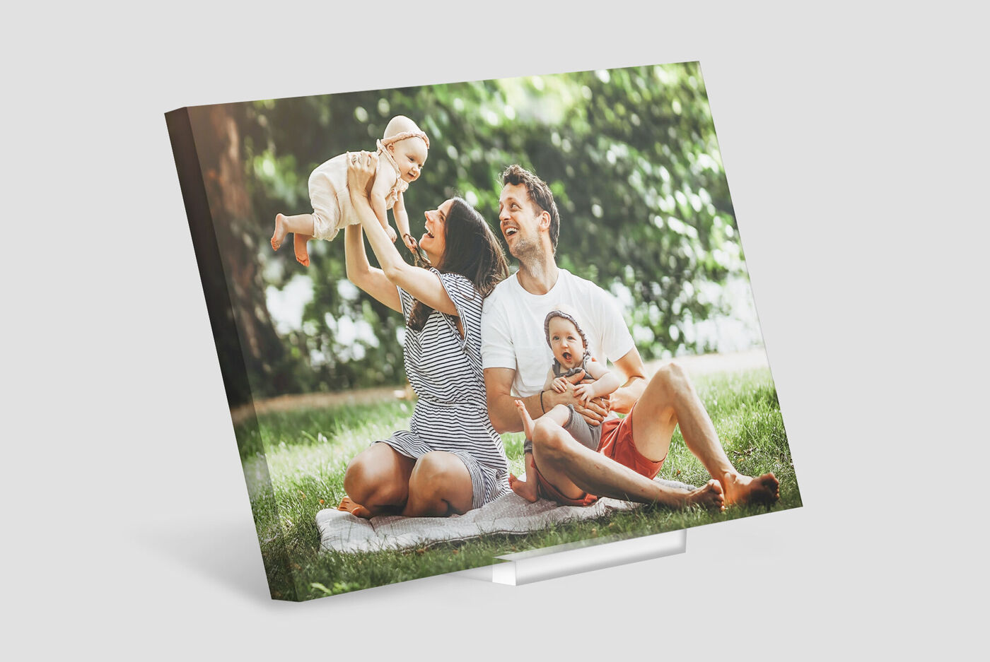 Family having fun outdoors with a small child in their arms