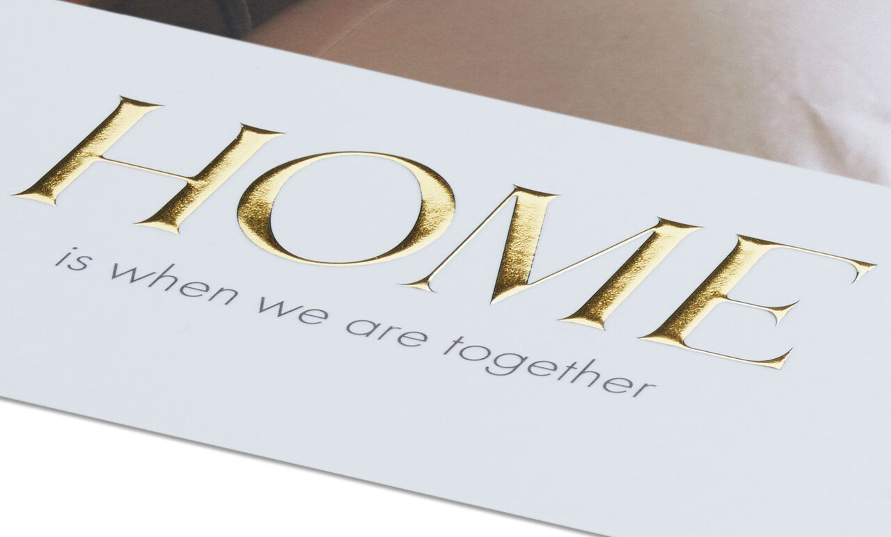 Wall art with the text 'HOME is when we are together' in gold and gray.