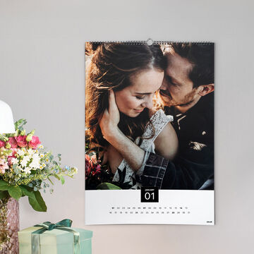 A beautiful calendar with a romantic image, surrounded by colorful flowers and a gift box