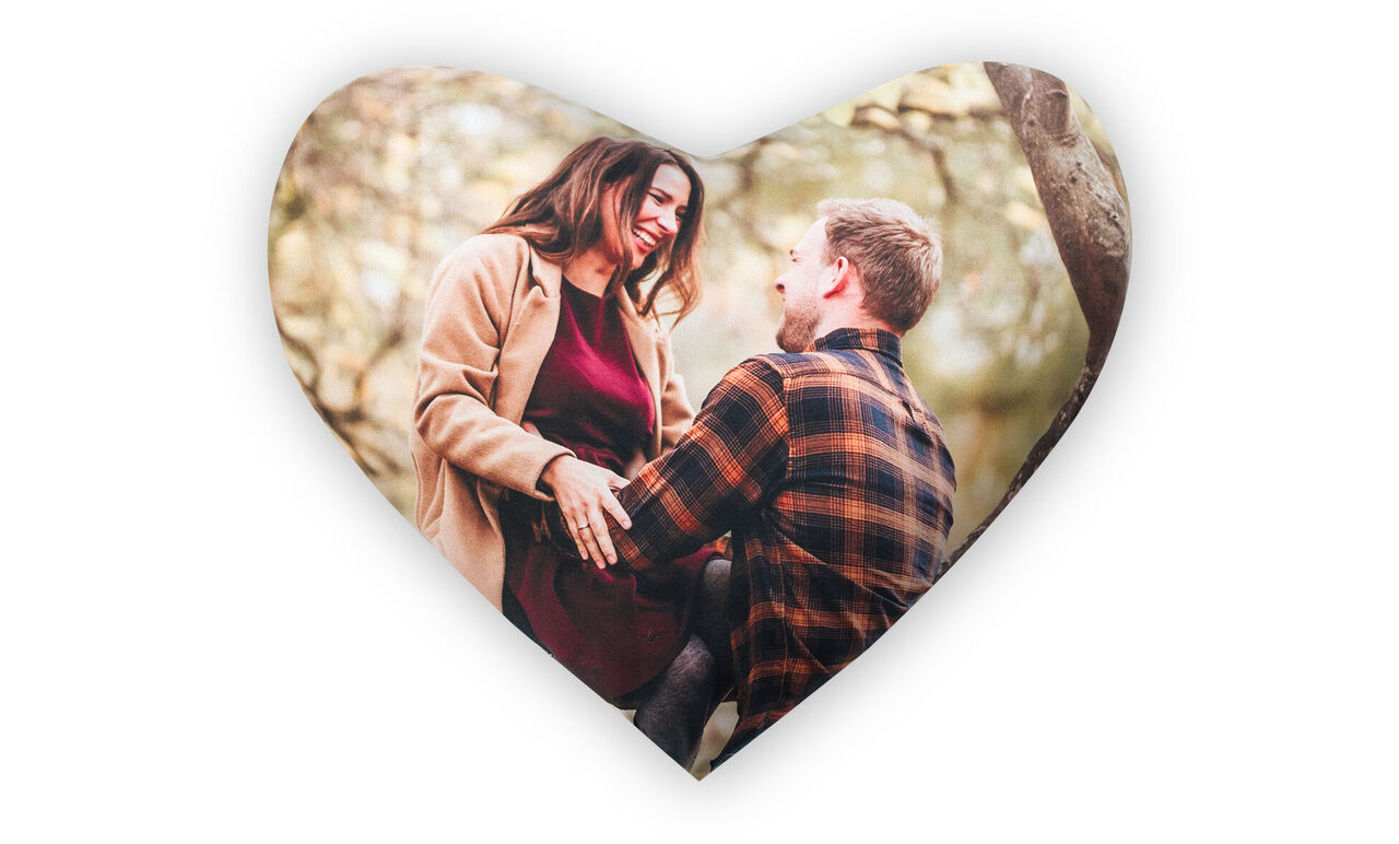 A couple sits in love outdoors, surrounded by trees, radiating joy and affection as they enjoy each other’s company.