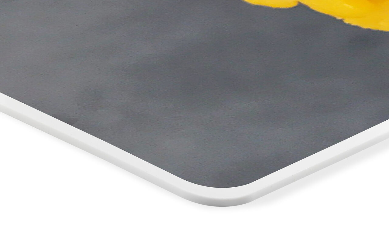 Corner view of a high-quality photo poster with a yellow flower on a gray background.