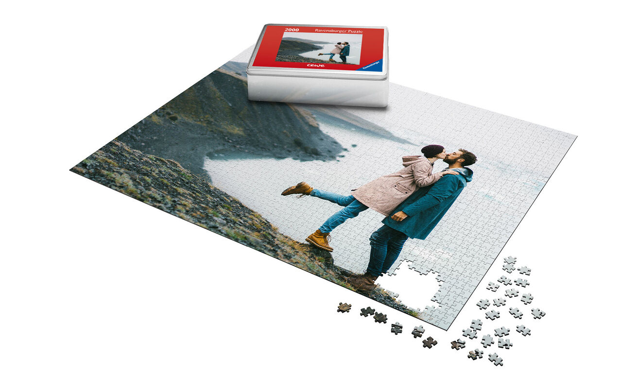 A couple kisses in front of a coastal landscape on a puzzle.