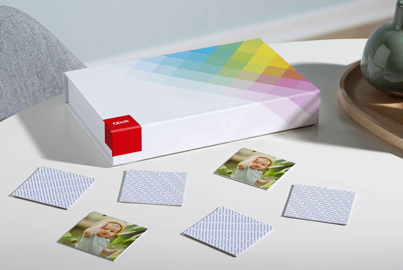 Colorful CEWE PHOTO BOOK box with photo cards on a table