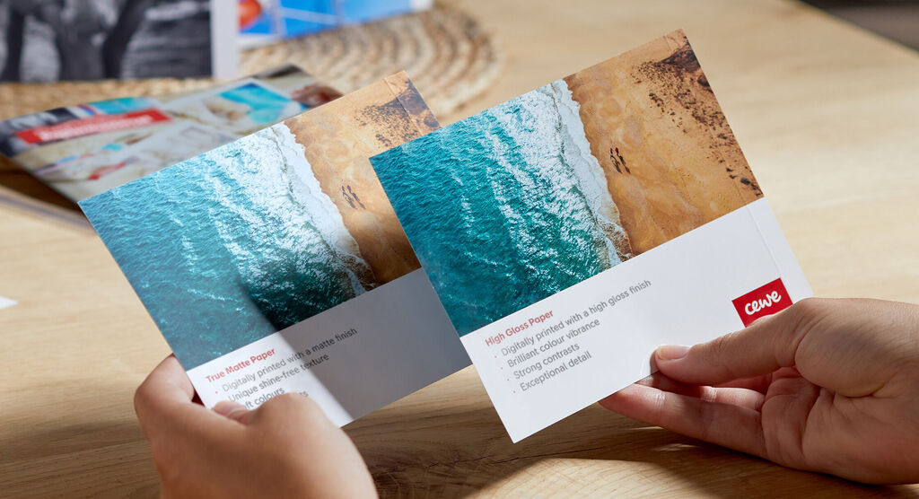 Two CEWE greeting cards with beach and sea images held in hands.