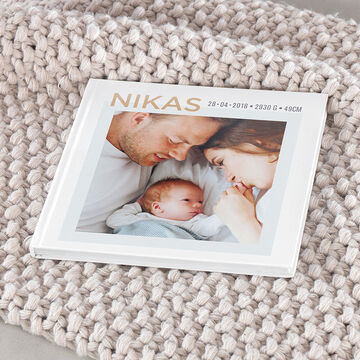 A lovingly designed photo book lies on a cozy blanket.