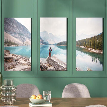 Three wall pictures with mountain landscape and lake, hanging in the room.