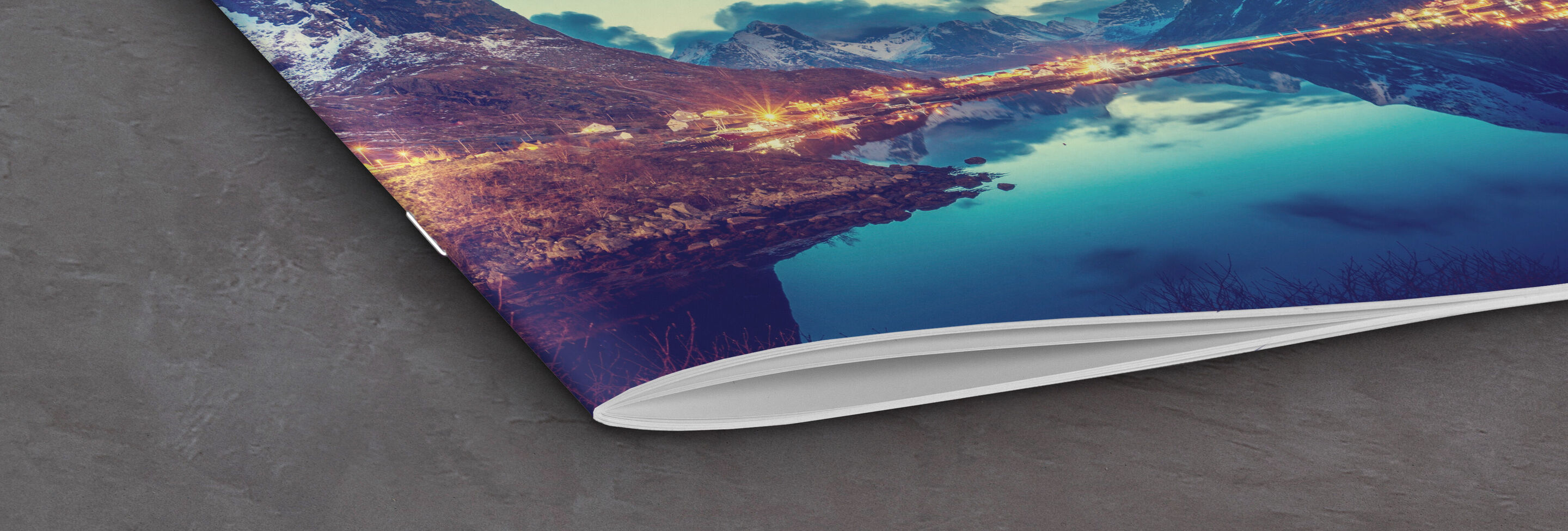 Close-up of an open CEWE photo book featuring a beautiful landscape on the page, surrounded by soft colors and a quiet background.