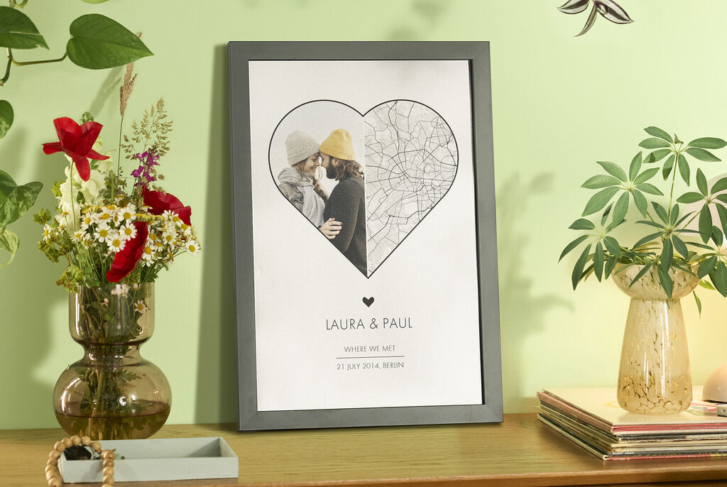 Loving couple in an embrace in a frame, surrounded by plants and flowers.
